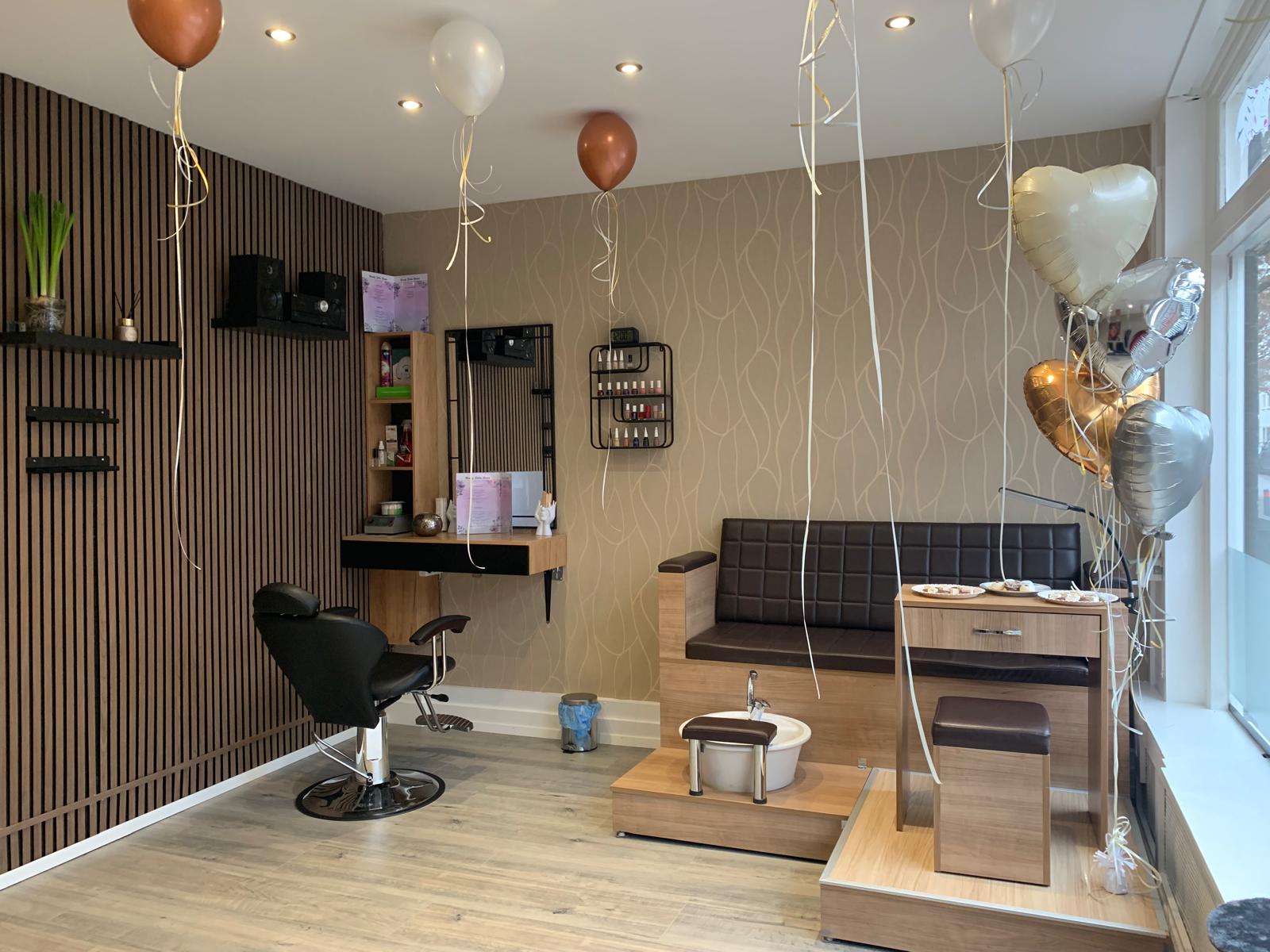De behandelstoel, de spiegel, het rek met nagellak en de pedicurebank in de salon